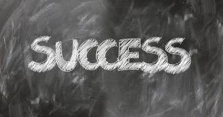 Das Bild zeigt eine Schultafel, auf der das Wort "Success" geschrieben steht